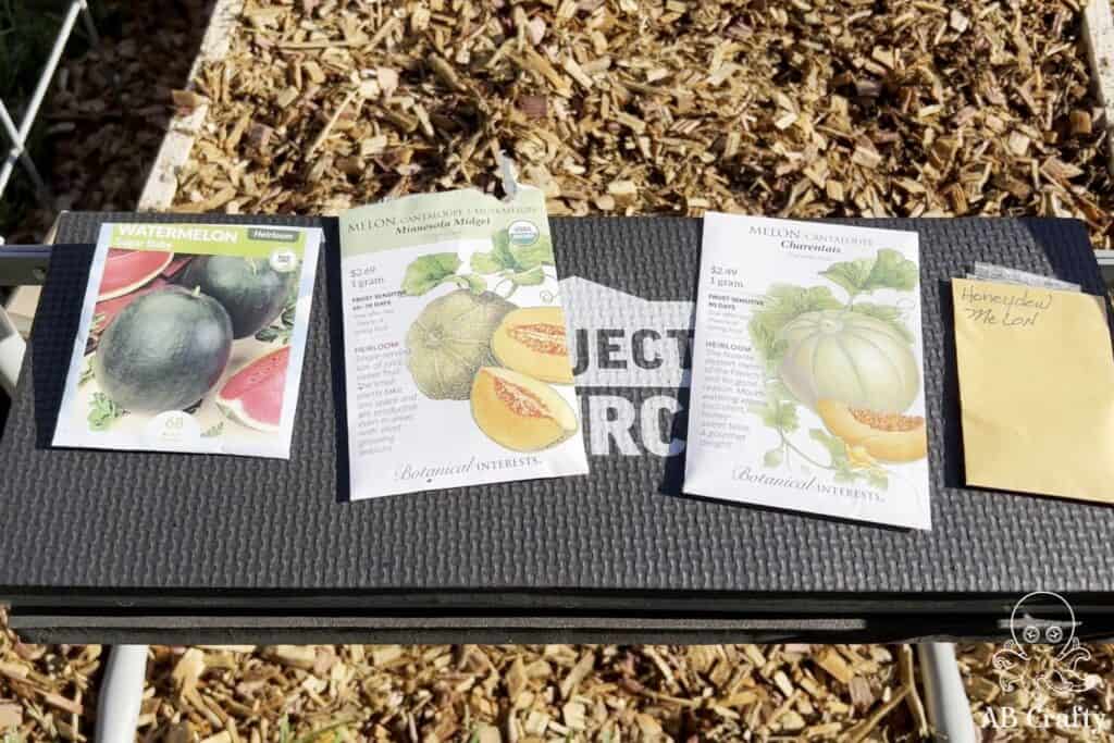 four types of melon seeds on top of a garden bench