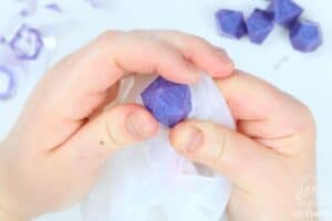 removing a purple resin d20 from the silicone dice mold