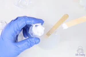 using a popsicle stick to scoop out some white silicone pigment