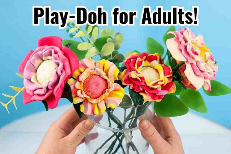 Hands holding a clear vase filled with vibrant multi-colored air-dry clay flowers, featuring the header text Play-Doh for Adults! against a light blue background.