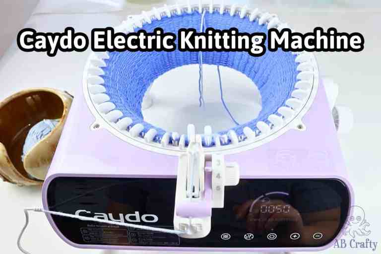 Top-down view of the Caydo electric knitting machine working on a blue yarn project with a text overlay reading "Caydo Electric Knitting Machine."